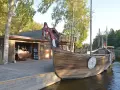 Drewniana łódź wikingów przy brzegu, obok chaty. Może to być widok z jednego z największych jezior w Szwecji.