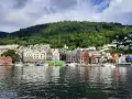Kolorowe kamienice nad wodą, zielone wzgórze w tle – idealne miejsce, by zobaczyć, co zwiedzić w Bergen.