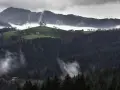 Mglisty krajobraz Beskidu Wyspowego z kościołem na wzgórzu i lasami.