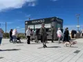 Ludzie stojący w kolejce do kasy biletowej "Kasa Molo" w Kołobrzegu.
