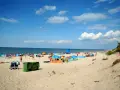 Plaża pełna ludzi, kolorowe parawany i namioty. Idealne miejsce, gdzie ciepła woda w czerwcu zachęca do kąpieli.