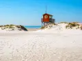 Piękne plaże w Szwecji z charakterystyczną czerwoną wieżą ratowniczą na wydmach.