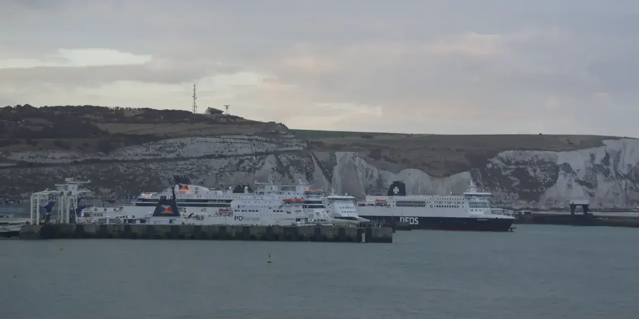 Promy z samochodami czekają na rejs do Anglii. Zastanawiasz się, ile kosztuje prom do Anglii z samochodem? Widok na białe klify Dover.