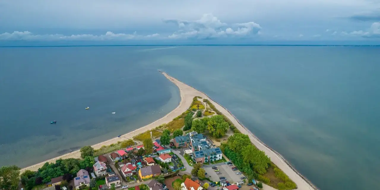 Widok z lotu ptaka na nadmorską miejscowość z plażą i morzem.