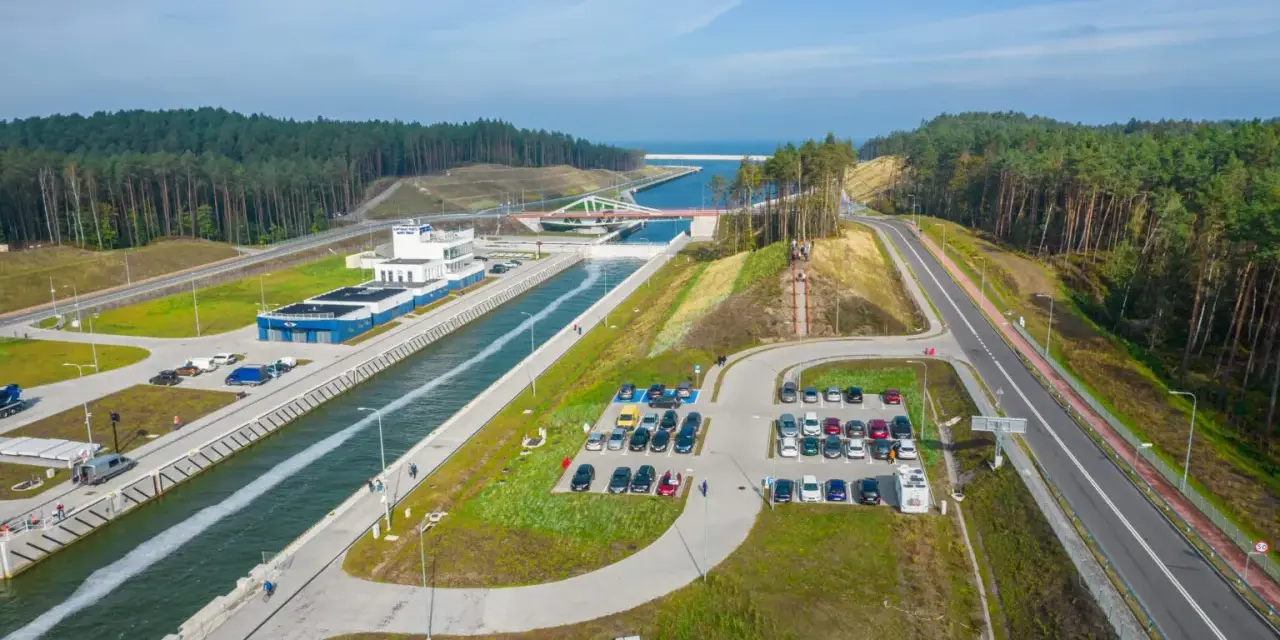 Widok z lotu ptaka na śluzę w Krynica Morska, kanał, parking i las.