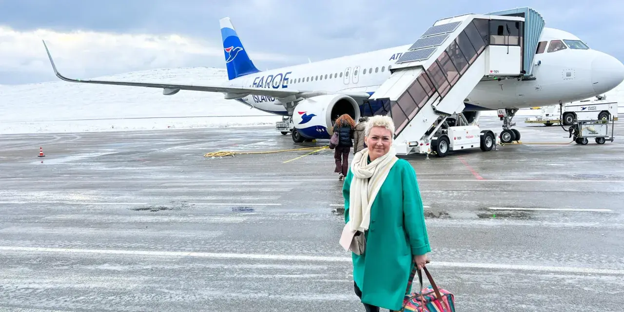 Kobieta z kolorową torbą na lotnisku, gotowa do podróży. Samolot Atlantic Airways z napisem "Faroe Islands" sugeruje, jak dostać się na Wyspy Owcze.