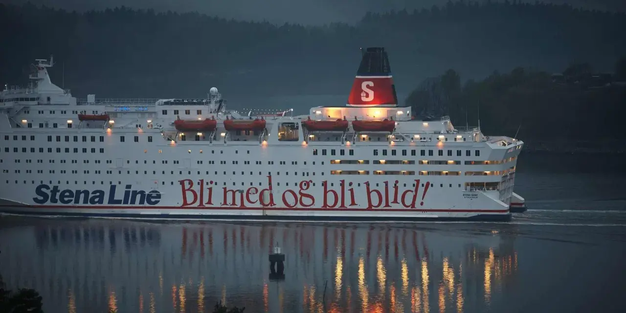 Duży biały prom Stena Line z czerwonym napisem "Bli med og bli blid!" płynie po wodzie o zmierzchu.