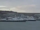 Promy z samochodami czekają na rejs do Anglii. Zastanawiasz się, ile kosztuje prom do Anglii z samochodem? Widok na białe klify Dover.