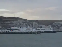 Promy z samochodami czekają na rejs do Anglii. Zastanawiasz się, ile kosztuje prom do Anglii z samochodem? Widok na białe klify Dover.