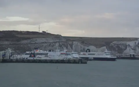 Promy z samochodami czekają na rejs do Anglii. Zastanawiasz się, ile kosztuje prom do Anglii z samochodem? Widok na białe klify Dover.