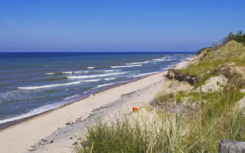 Plaża nad Bałtykiem, fale rozbijają się o brzeg. Czy morze bałtyckie jest słone? Tak, nawet w upalny dzień.