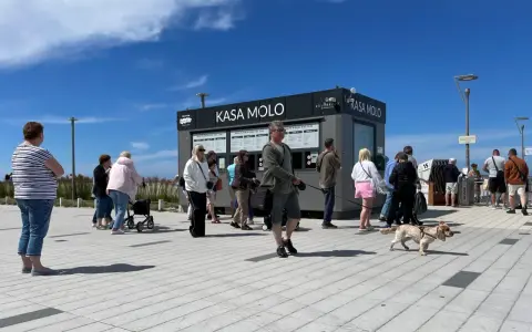 Ludzie stojący w kolejce do kasy biletowej "Kasa Molo" w Kołobrzegu.