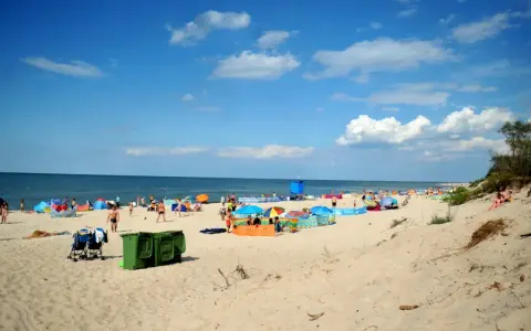 Plaża pełna ludzi, kolorowe parawany i namioty. Idealne miejsce, gdzie ciepła woda w czerwcu zachęca do kąpieli.