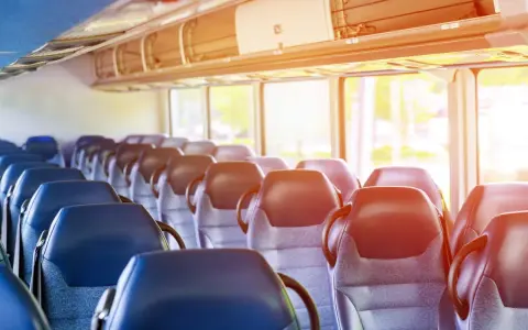 Puste siedzenia w autobusie lub pociągu z widokiem przez okno.