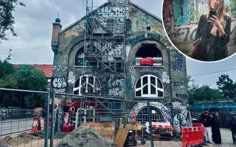 Kopenhaga nietypowe miejsca: zrujnowany budynek z graffiti i rusztowaniami, w tle kobieta robiąca selfie.