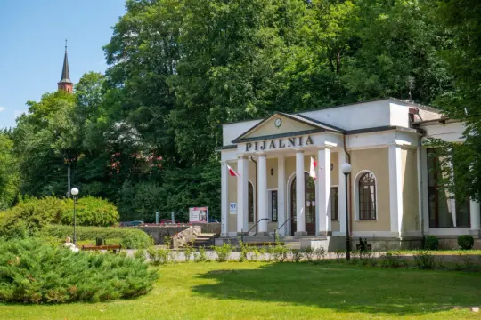 Uzdrowiskowa Pijalnia w Dusznikach-Zdroju, jedna z głównych atrakcji, otoczona zielenią.