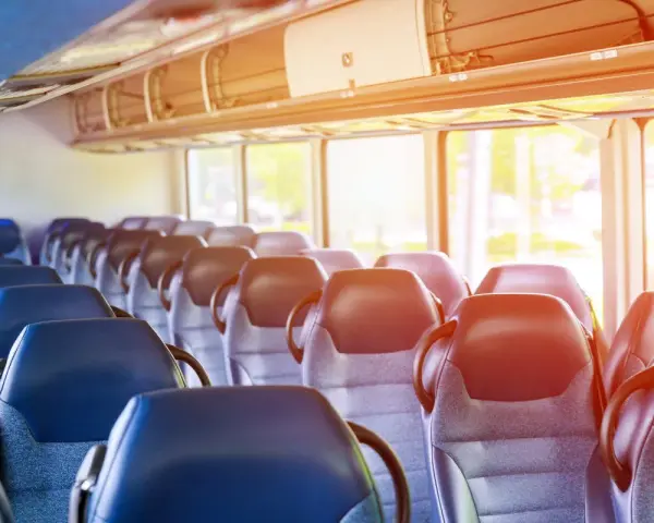Puste siedzenia w autobusie lub pociągu z widokiem przez okno.