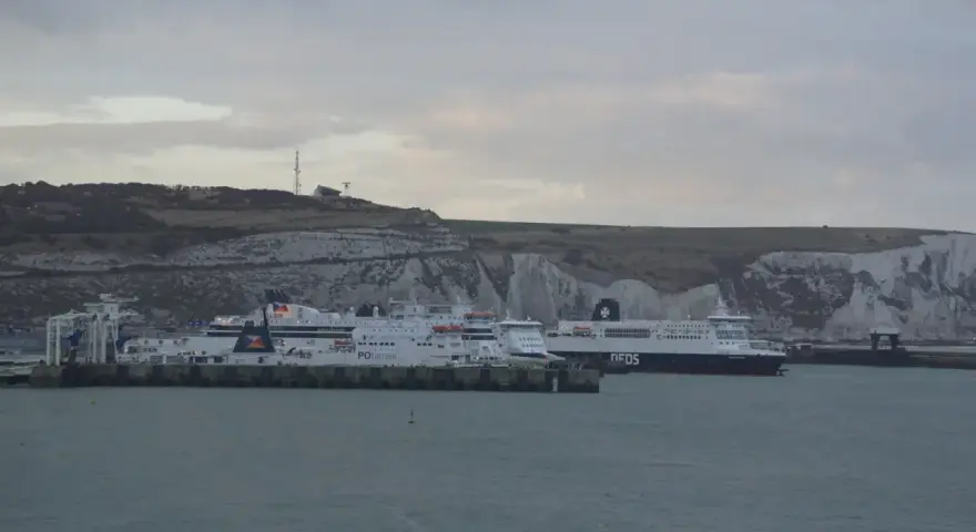 Promy z samochodami czekają na rejs do Anglii. Zastanawiasz się, ile kosztuje prom do Anglii z samochodem? Widok na białe klify Dover.