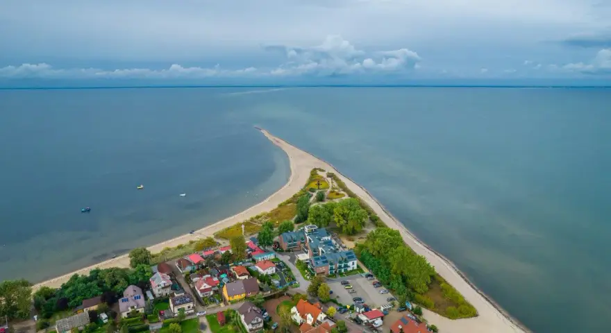 Widok z lotu ptaka na nadmorską miejscowość z plażą i morzem.