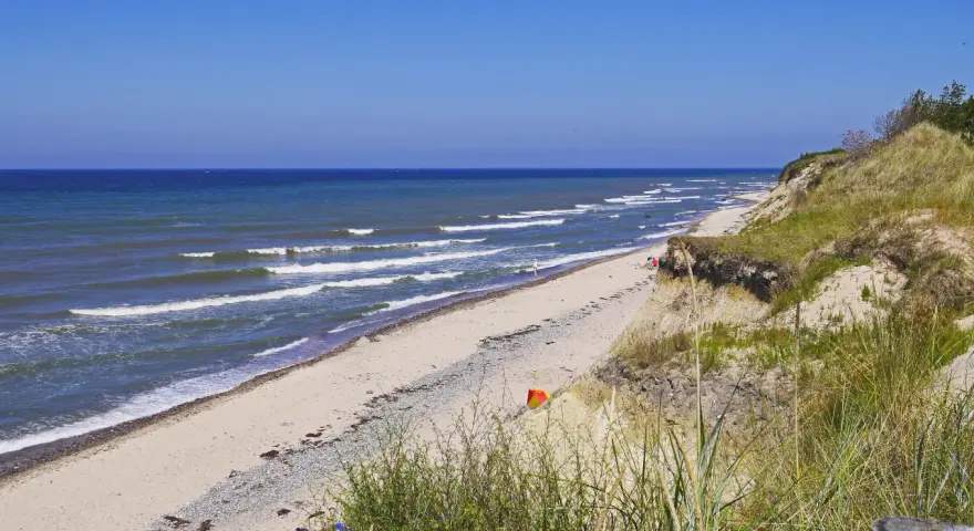Plaża nad Bałtykiem, fale rozbijają się o brzeg. Czy morze bałtyckie jest słone? Tak, nawet w upalny dzień.