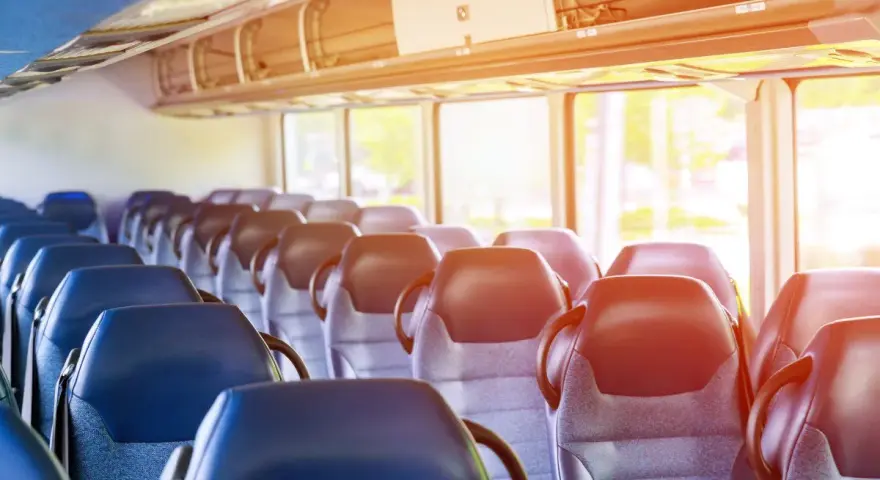 Puste siedzenia w autobusie lub pociągu z widokiem przez okno.