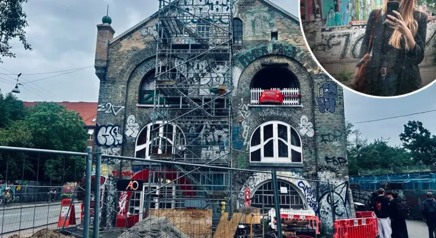 Kopenhaga nietypowe miejsca: zrujnowany budynek z graffiti i rusztowaniami, w tle kobieta robiąca selfie.
