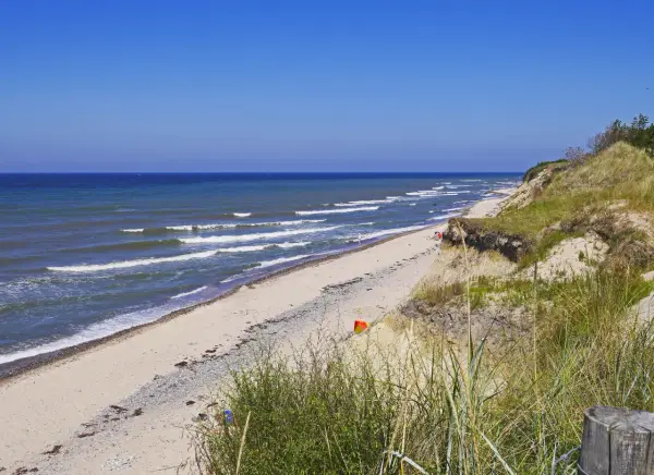Plaża nad Bałtykiem, fale rozbijają się o brzeg. Czy morze bałtyckie jest słone? Tak, nawet w upalny dzień.