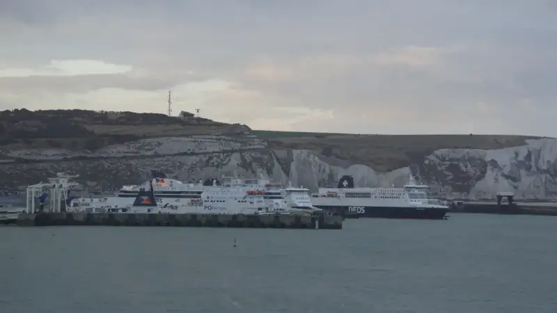Promy z samochodami czekają na rejs do Anglii. Zastanawiasz się, ile kosztuje prom do Anglii z samochodem? Widok na białe klify Dover.