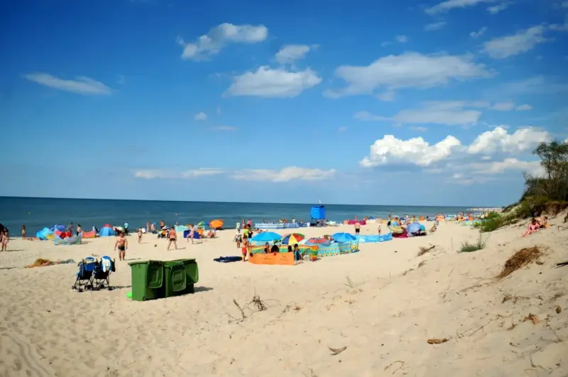 Plaża pełna ludzi, kolorowe parawany i namioty. Idealne miejsce, gdzie ciepła woda w czerwcu zachęca do kąpieli.
